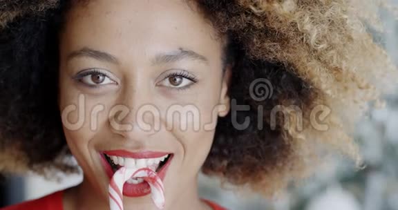 有趣的年轻女人咬圣诞糖果视频的预览图