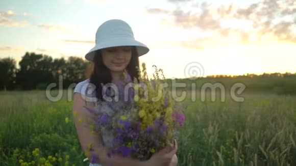 年轻女子带着田野的鲜花漫步视频的预览图