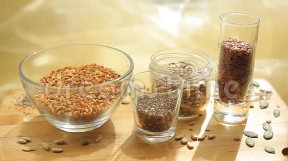 碗和玻璃杯里不同种类的种子辣椒荞麦亚麻籽视频的预览图