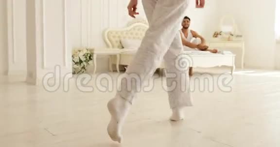 女人在床上蹦蹦跳跳男人拥抱她的夫妇在家里的卧室视频的预览图