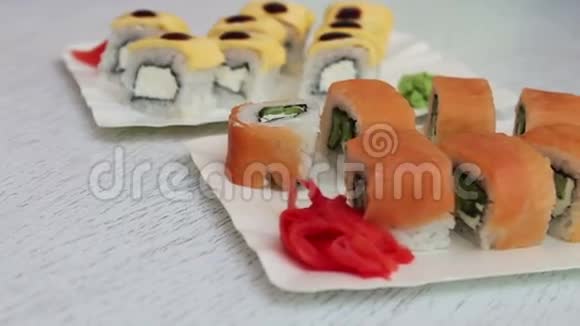 新鲜美味的寿司里面有三文鱼生姜奶酪和芥末放在咖啡厅的白色盘子里视频的预览图