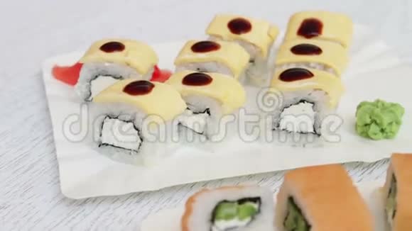 新鲜美味的寿司里面有三文鱼生姜奶酪和芥末放在咖啡厅的白色盘子里视频的预览图