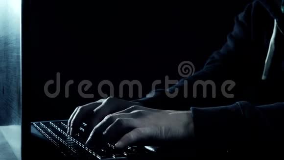 黑暗的夜晚男人用手在笔记本电脑键盘上打字视频的预览图