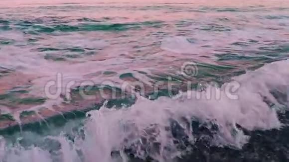 日落后的粉红海冲浪慢动作视频的预览图