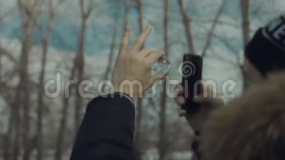 男人通过玻璃球在手机上拍照视频的预览图