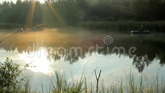 渔夫乘一艘充气船在河上漂浮太阳的光线在镜框里播放野外活动视频的预览图