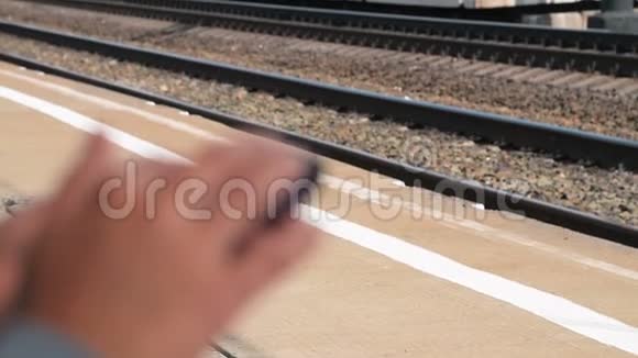 在站台上等火车时使用手机视频的预览图