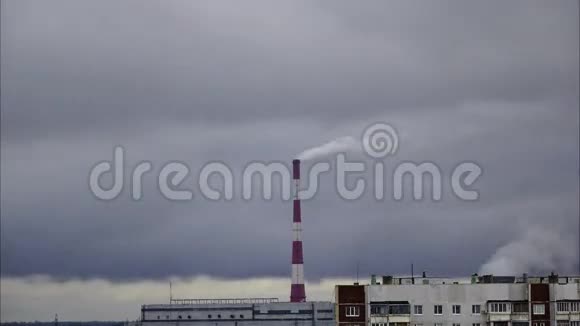 大型工厂烟囱在快速移动的灰云背景下冒烟灰色的秋日时间流逝视频的预览图