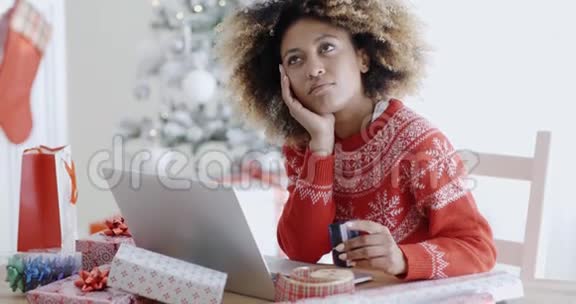 年轻女子在考虑网上购买视频的预览图