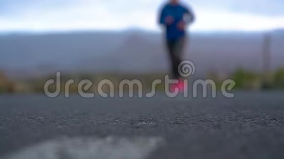 跑鞋在山区沙漠公路上系鞋带的女人视频的预览图