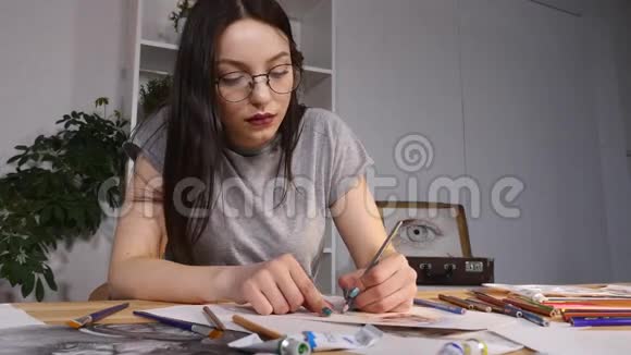 女画家正坐在办公室里画素描她戴着眼镜视频的预览图
