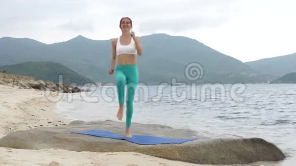 健身微笑的女人在日落时在海滩上做运动锻炼视频的预览图