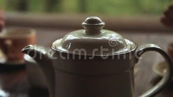 木桌上的白瓷茶壶视频的预览图
