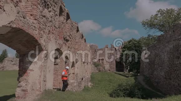 建筑工人检查一座古堡的废墟视频的预览图