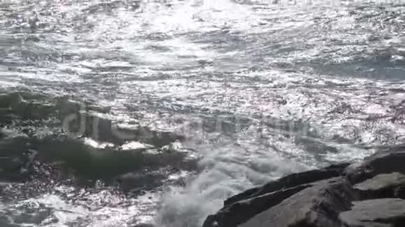 一个美丽的海洋沙滩与蓝色的波浪滚动到海岸一些岩石呈现视频的预览图