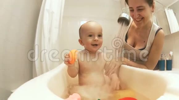 可爱的小男孩洗澡和泼水的慢镜头视频的预览图