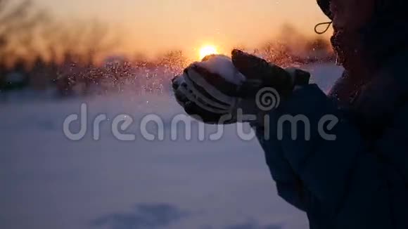 少年用双手吹雪背景是夕阳视频的预览图