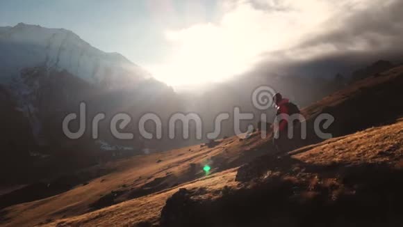 在美丽的日落中一个女孩在山的边缘行走的史诗般的画面视频的预览图