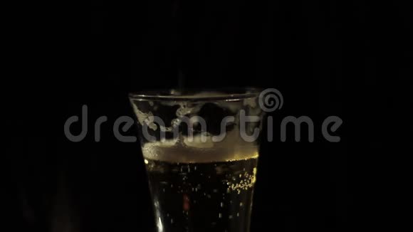 在黑色背景下将啤酒倒入玻璃杯中视频的预览图