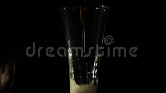在黑色背景下将啤酒倒入玻璃杯中视频的预览图