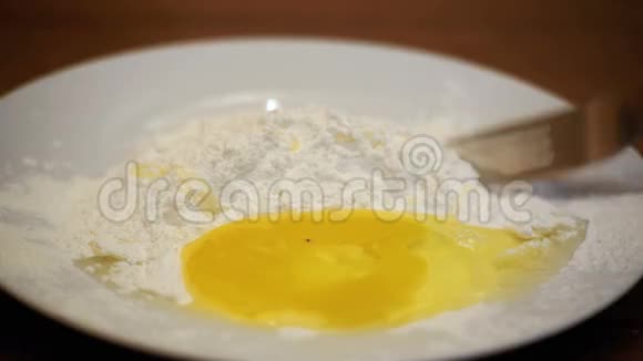 在碗中用叉子用面粉吹蛋视频的预览图