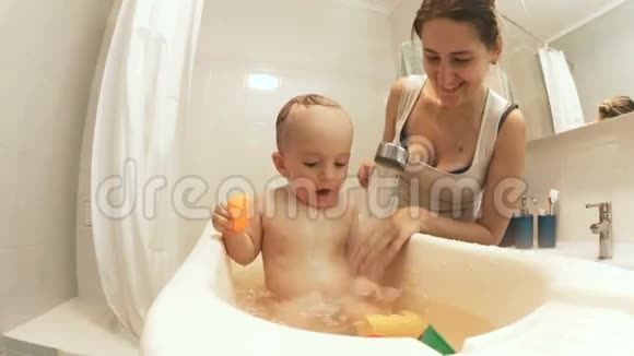 可爱的小男孩洗澡和泼水的慢镜头视频的预览图