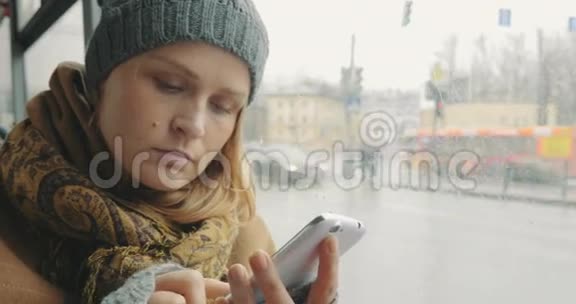 在公共汽车上车时用手机发短信的女人视频的预览图