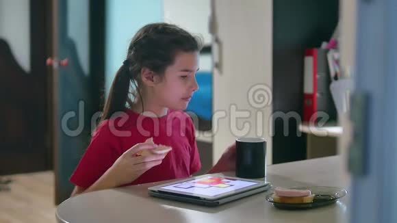 少女正在吃三明治在平板电脑上玩一个网络游戏儿童社交媒体平板电脑室内视频的预览图