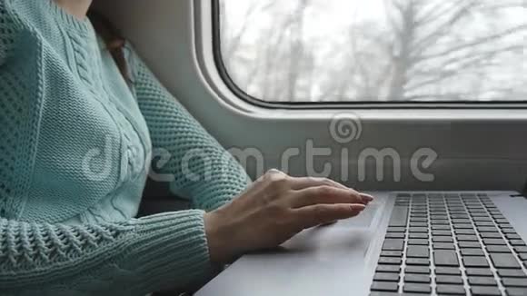女性手在火车上使用笔记本电脑的触摸板年轻女性在旅行中触摸笔记本触摸屏的手臂视频的预览图