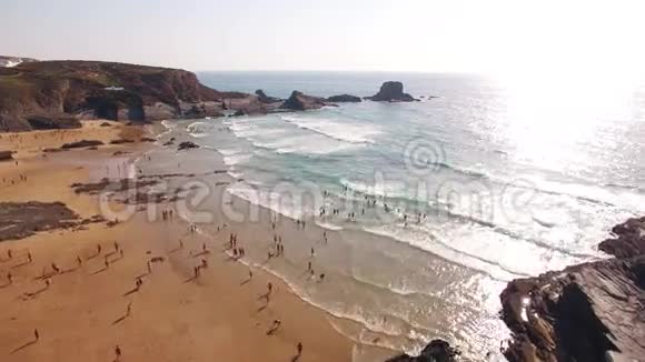 人们在靠近岩石的海滩上放松视频的预览图