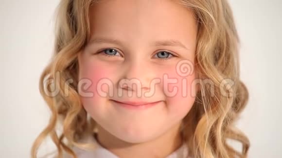 特写镜头可爱的小可爱的小女孩蹒跚学步的孩子红润的脸颊金色的卷发在镜头中微笑视频的预览图
