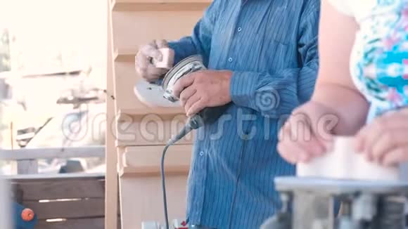 木匠在磨床上打磨一个木制部件特写双手视频的预览图