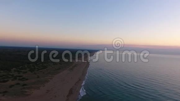 空中拍摄平静的大海在夕阳下落下视频的预览图