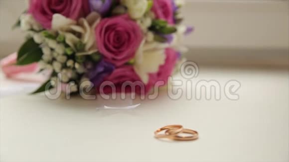 结婚戒指和玫瑰结婚首饰和戒指一个盒子上的美女结婚戒指金色结婚戒指视频的预览图