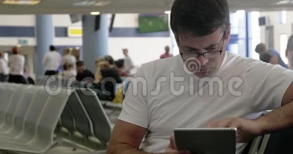 在机场用触摸板工作的年轻人视频的预览图