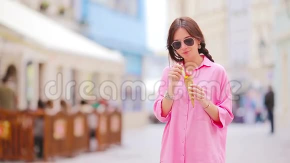 年轻的女模特在户外吃冰淇淋夏季概念热天带甜冰淇淋的女人视频的预览图
