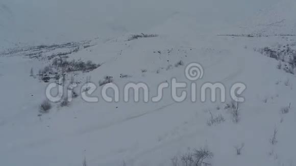 在山上行驶大雪纷飞的道路鸟瞰视频的预览图
