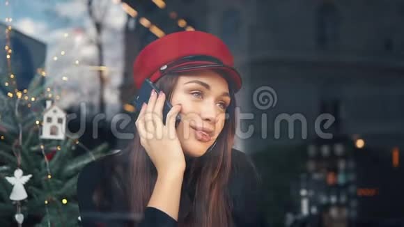 在寒冷的冬日里一个幸福的女人坐在舒适的咖啡馆里打电话视频的预览图