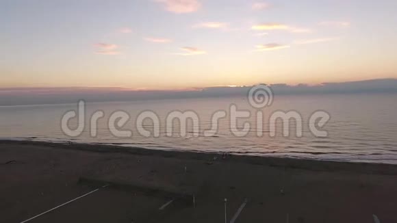 空中拍摄平静的大海在夕阳下落下视频的预览图