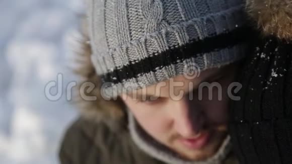 一个年轻人和一个穿着温暖冬天衣服的女孩在一个下雪的冬天公园里享受彼此的存在视频的预览图