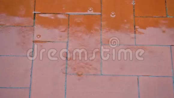 雨点落在红色的地板上溅起大雨水流和气泡视频的预览图