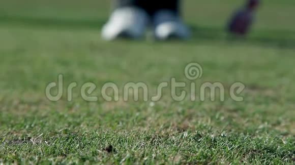 一个高尔夫球手近距离的朝一个点走在那里他打出一个白色的高尔夫球视频的预览图