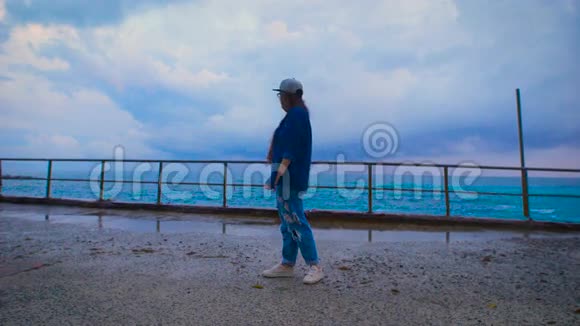 年轻女子站在码头上的巨浪附近秋天的冬天暴风雨视频的预览图