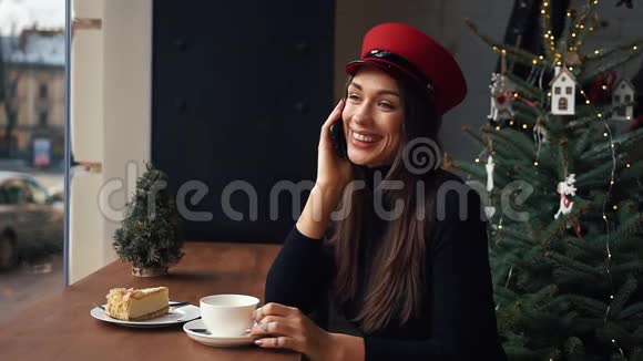 在寒冷的冬日里一个幸福的女人坐在舒适的咖啡馆里打电话视频的预览图