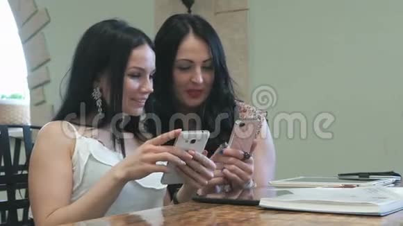 两个女孩正在手机上看照片视频的预览图