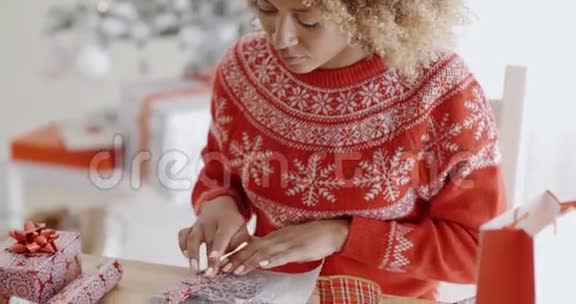 年轻女子小心翼翼地包装圣诞礼物视频的预览图