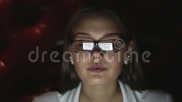 一个戴眼镜的年轻女人晚上工作的肖像特写侧脸视频的预览图