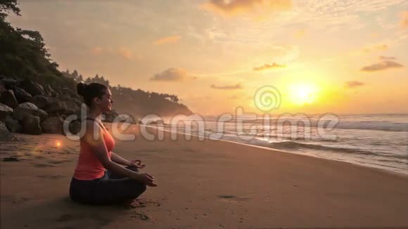 日落时分在海滩上沉思的女人视频的预览图