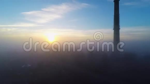 日出时高高的未使用的烟囱在晨雾上方空中镜头令人惊叹的光视频的预览图