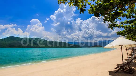蔚蓝的大海绿色的岛屿海滩伞椅子前景视频的预览图
